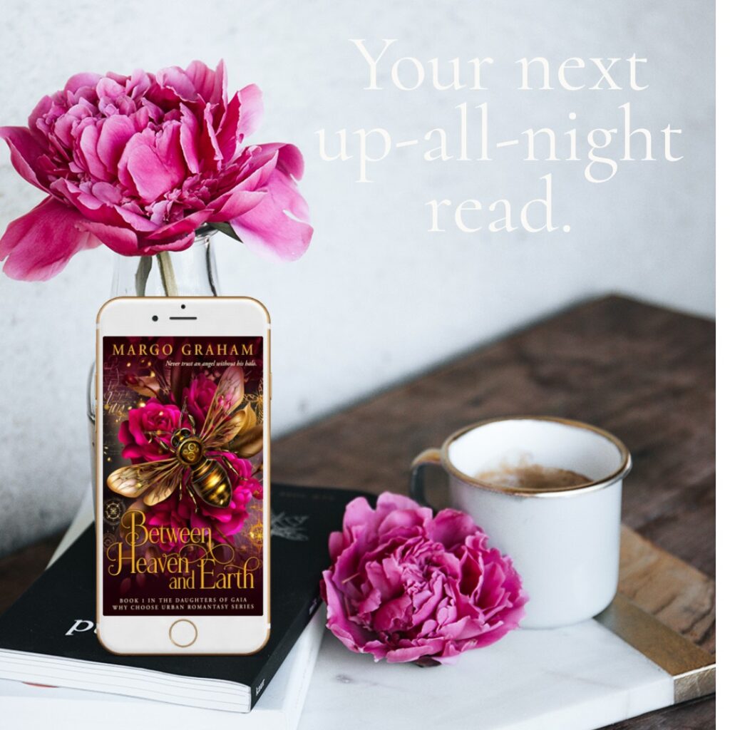 A cellphone showing the book cover of Between Heaven and Earth sitting amid roses and tea on a table.